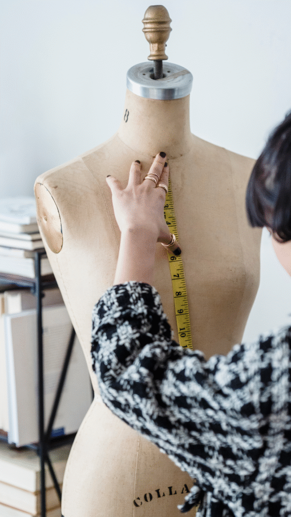 Main mesurant un buste de couture avec un mètre ruban, représentant un service sur-mesure en gestion des réseaux sociaux.